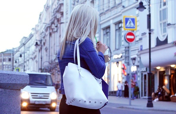 woman carrying a white purse